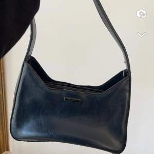 Liten mörkblå handväska , lite defekter förekommer men fint skick. 