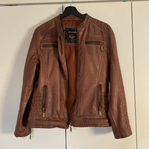 Brun läderjacka  - Säljer denna fake läder jacka då den ej kommit till användning, helt oanvänd med nypris 1000kr mitt pris 400:)