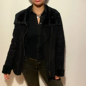 Svart jacka - Denna fina och mysiga jacka i mocka imitation är fluffig och skön på insidan. Den är praktisk och går att stänga hela vägen upp när det blir lite kallare. Passar bra nu på vintern! Storleken är L men skulle säga att det är en M. 