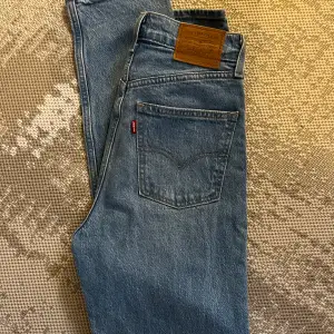 Oanvända Levis jeans i modellen 70’s high slim straight. Storlek W25 L31 