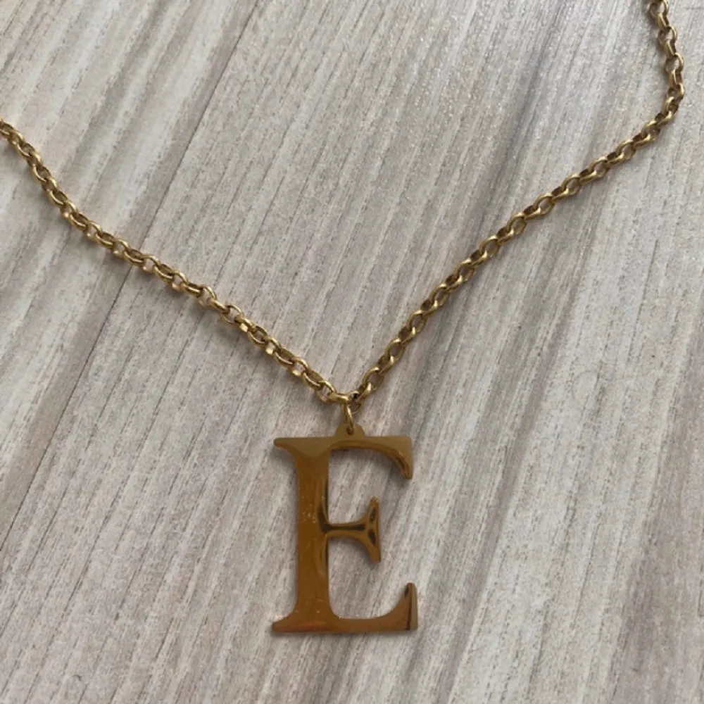 Säljer detta halsband med guldfärg med bokstaven E . Accessoarer.