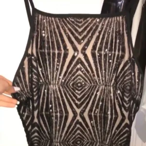 Kort festklänning  - En kort, svart och beige glittrig festklänning som jag haft på min en gång. 