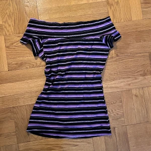 Randig off-shoulder - Supersnygg off-shoulder topp, med ränder varav en av de är glittrig. Perfekt till både vardags och fest