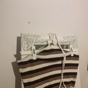 Croppad topp med band runt nacken - Aldrig använd men ingen lapp,vit randig med olika nyanser av brun.