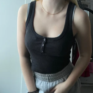 Svart topp med knappar - Jättesöt svart topp som inte längre kommer till användning. Inga slitningar eller fläckar och heller inte jätteanvänd. Väldigt bra skick!🤍