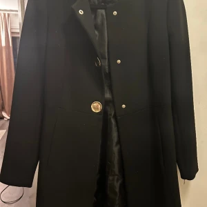 Snygg classy kappa från zara  - Storlek xs/34  Knappt använd!!!! Testad några gånger men inte varit min typ av kappa.  Funkar perfekt till om man är kort! Jag är 150cm, den är inte för lång! I perfekt skick inga skador då den knappt är använd. Sitter jätte fint slimmad. Nypris 799