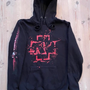 Svart Rammstein Hoodie (Officiell Merch) - Rammstein ”Melin Herz Brennt” hoodie. Size: small Aldrig använd så mycket fint skick! (Säljes pga felköpt storlek) Officiell Rammstein Merch Tryck finns fram, bak, och på ena ärmen, ändarna på snoddarna är i metall med gravyr.