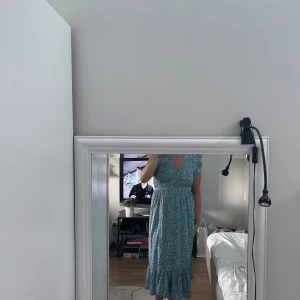 Blå klänning  - Super fin blommig blå klänning med snörning och volang. Aldrig använd, super bra material och storlek.