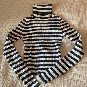 Ribbad, randig, långärmad topp med krage. - Tunn och nästintill oanvänd. Mörkgrå och gråvit randig.