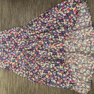Kjol - Blommig kjol från Gina tricot i storlek 44.  Asymmetrisk och är kortade framtill, se bild.