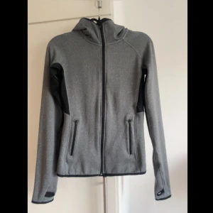 Träningströja - Sparsamt använd träningströja med luva och fickor. Fint skick! Väldigt stretchig så den passar även en S