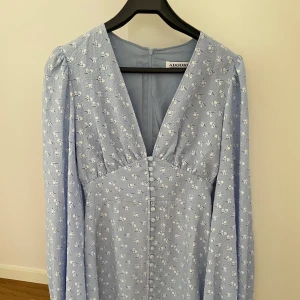 Florence Dress - Sprillans ny Adoore klänning som aldrig är använd, enbart testad. Ljusblå klänning i storlek 38 med dragkedja därbak. Nypris: 1 495. Mitt pris: 720kr  Korta modellen.  