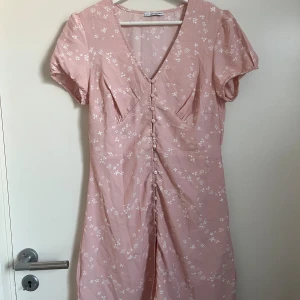 Rosa klänning med blommor - Rosa klänning med vita blomdetaljer, använd endast en gång, storlek 38,  Nelly x Glamorous