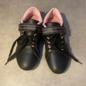 Sneakers- svart - Svarta firefly sneakers med rosa insida och rosa detaljer på utsidan. Skorna är använda lite och därför har lite skavanker men är fortfarande i mycket bra skick.