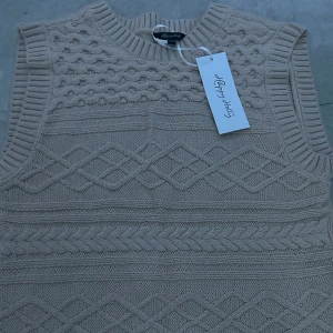 Stickad väst  - En oanvänd stickad beige väst