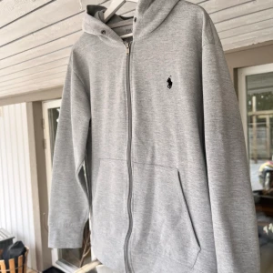 Grå Ralph Lauren zip - Säljer nu min galet feta Ralph lauren zip hoodie. Tröjan är i storlek M, sitter lite litet på mig som är 190 lång. (skriv för bild) har ej äkthetsbevis men ser inget som tyder på att den ej är det. Har en liten fläck men inget man lägger märke till.