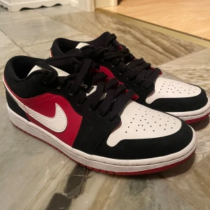 Air Jordan 1 Low röd/svart/vit - Storlek 40, nästintill oanvända, inget som är fel som ni kan se. Säljer de med boxen som ingår.  Passar både män och kvinnor. Kan tänka mig gå ner i pris vid snabb affär