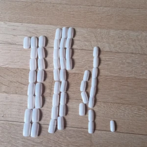 Blandade lösnaglar med klisterlappar - Vita lösnaglar som är väldigt olika storlekar och de största är stora men man kan ju fila. Det är 10 kr för hela påsen alltså med klisterlapparna