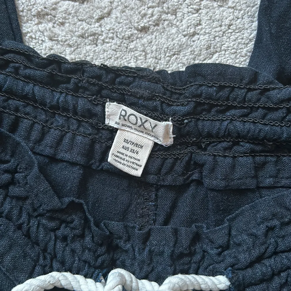 Svarta linnebyxor från Roxy i storlek XS. Dom är i mycket bra skick förutom ett litet hål bak på byxan, se bild.. Jeans & Byxor.