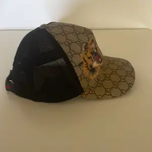 Äkta GUCCI keps. Storlek XS (56cm) men man kan justera storleken med hjälp av kardborrebandet. Köpt för 3200kr och haft den i mindre än ett år så den är k bra skick  Jag säljer denna eftersom jag använder inte den inte längre.