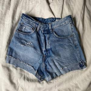 Högmidjade jeansshorts med slitningar, knappt använda, stl 36, normal passform