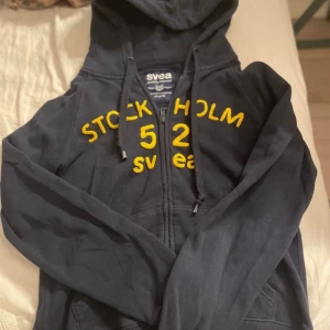 Mörkblå Stockholm Svea zip hoodie - Jag säljer denna fina Svea zip hoodie!! Lite söndrig vid banden men inget man märker💘 Storlek M men passar som S