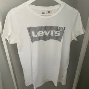 Vit T-shirt med silvrig Levis-logga från Levis i storlek S. Bra skick!✨ Köparen står för frakten, kan mötas upp i Kalmar!