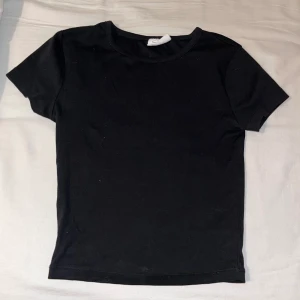 Tight T-shirt - En tightare t-shirt i mjukt material, ifrån Gina tricot Basically basic. Säljes i storlek XS för 50kr. Original pris koms inte ihåg, och i väldigt bra ny skick, då den ej blivit använd pga fel passform. 