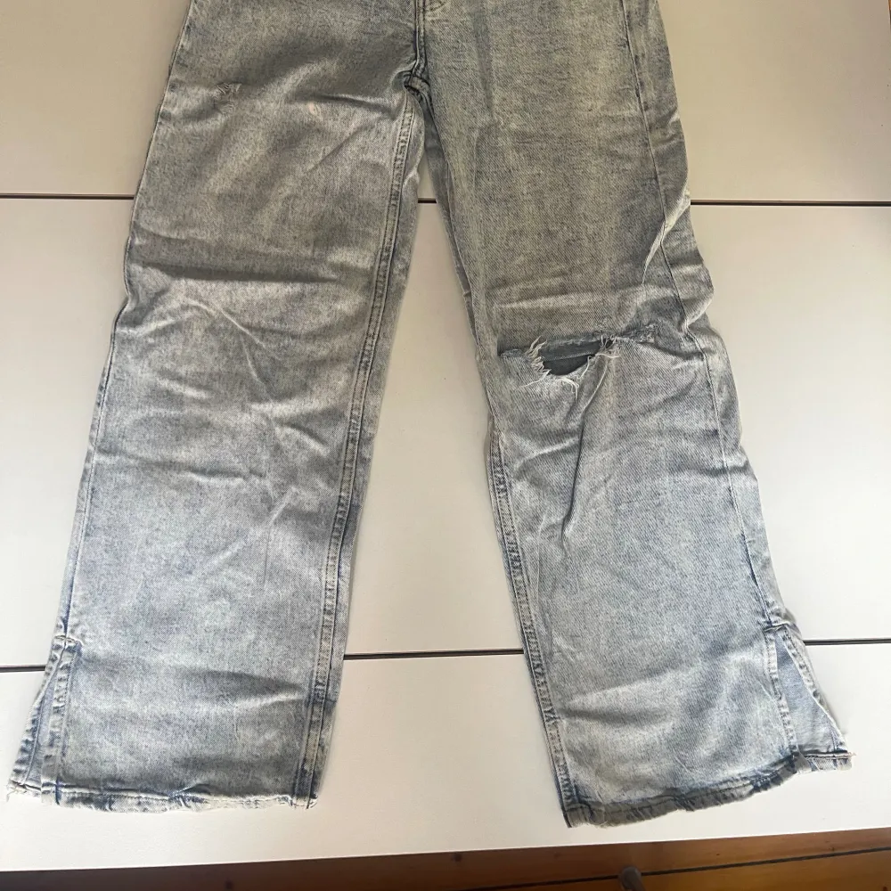Stentvättademede ljust gråblå jeans med vida ben och ett par revor/hål (inte slitage utan nött look). Skrynkliga på bilden. . Jeans & Byxor.