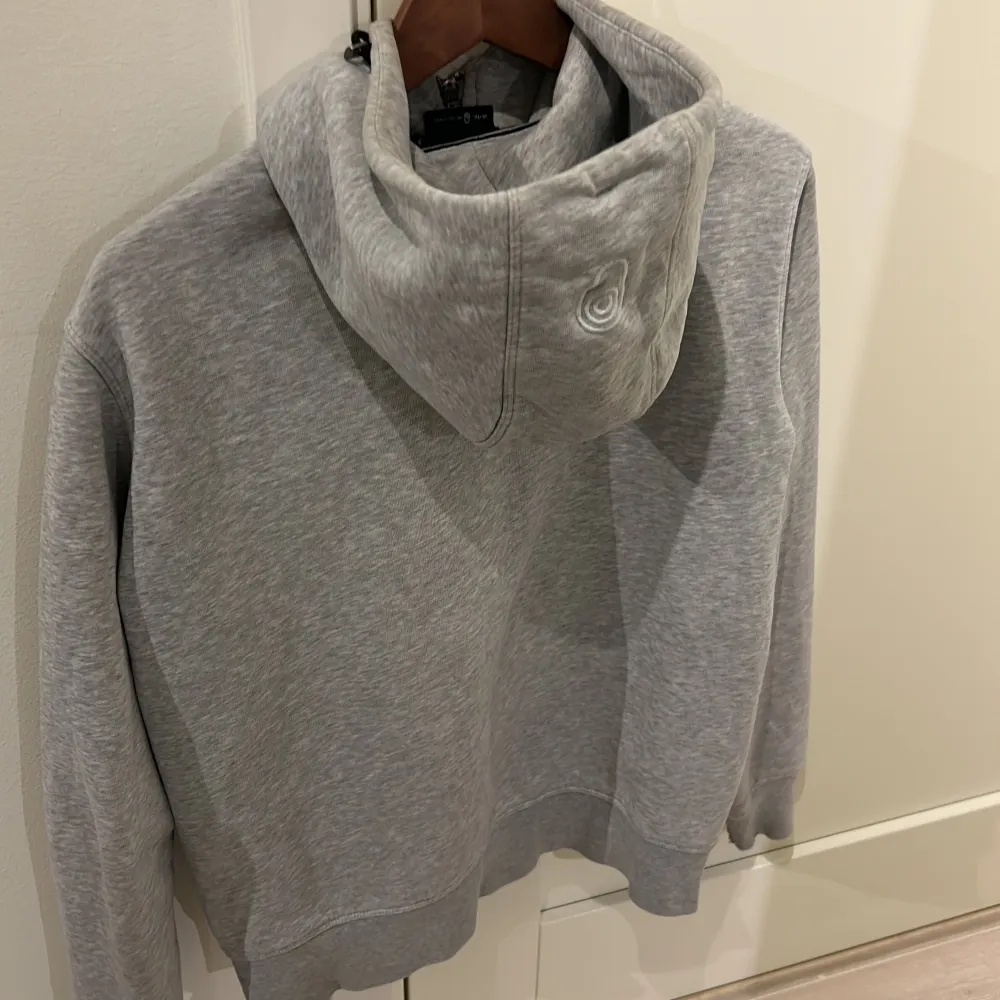  En grå Sail racing hoodie, har små defekter på änden av armarna men märks knappt, prutbar. Hoodies.