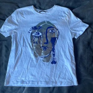 Zara T-shirt  - En fin T-shirt från Zara nästan helt ny, knappt använd. Den har ett coolt tryck i silver och marin blått.