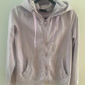 Ljuslila hoodie i strl S - Använd, finns några få mindre nopper i övrigt i bra begagnat skick.  Mått Över axeln: ca 41 cm Längd från axeln och ner: ca 59 cm  Bomull och polyester   Kommer från ett djur och rökfritt hem.