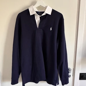 Polo Ralph Lauren rugbytröja - En marinblå rugbytröja från RL. Aldrig använd. Nypris 1900 kr. 