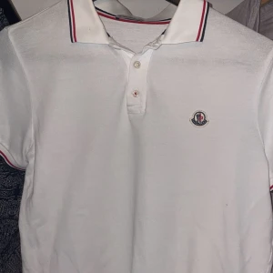 Moncler Piké - Säljer denna moncler piké som jag använde förra sommaren. Har tyvärr växt ur den nu. Skick: 8/10 väldigt små defekter men annars perfekt! Köpt ny på NK Stockholm för 2200kr