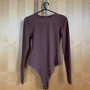 Basic bodysuit  - Aldrig använd. Basic brun bodysuit.  Bianca Ingrosso’s kollektion med Nelly.