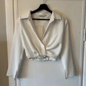 Vit skjortblus från Zara i storlek M. Blusen är croppad och har en dragkedja på sidan. Har använt 1 gång men har tyvärr blivit för liten. 