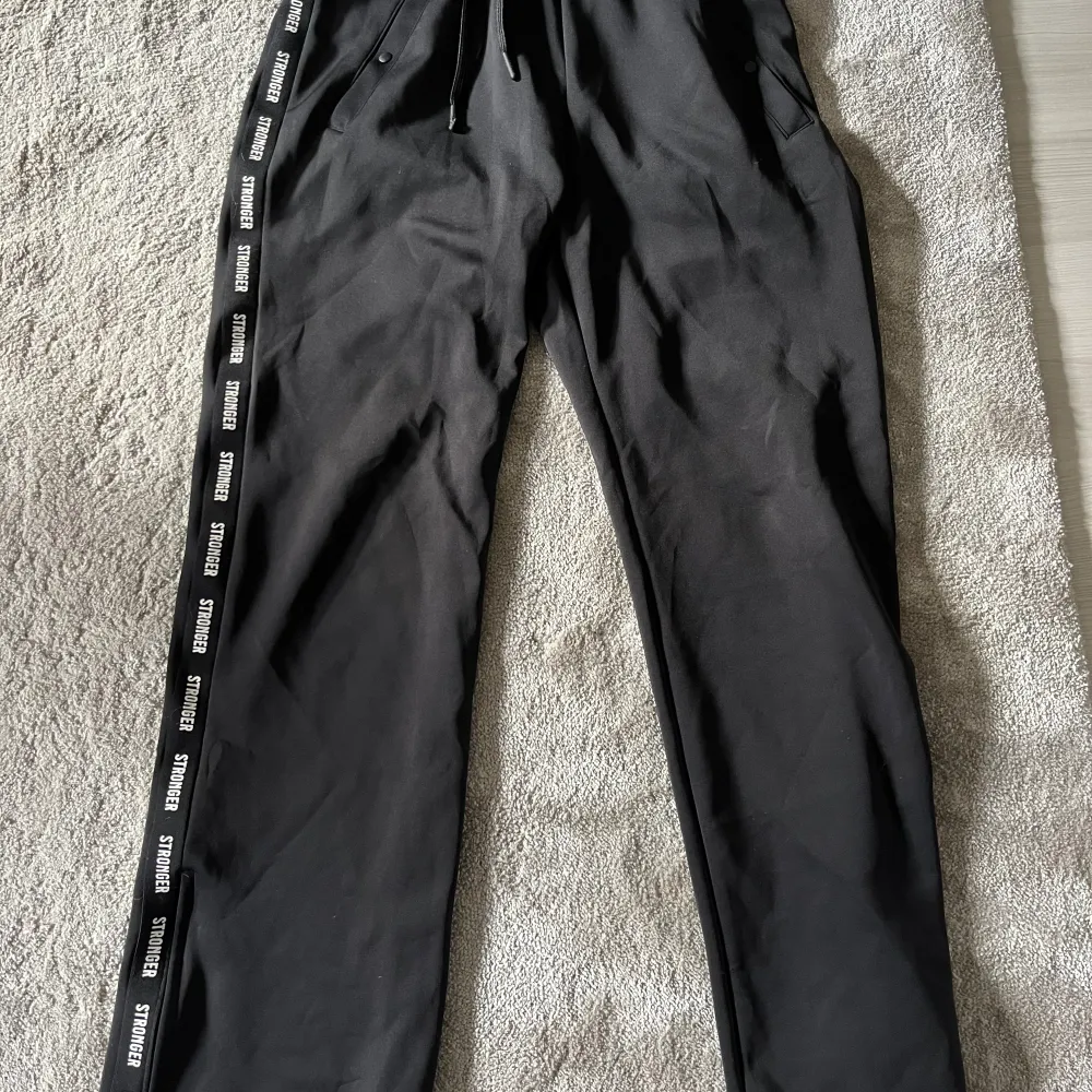 Svarta mjukisbyxor från Stronger. Hög midja, två fickor, dragkedja i byxbenet att dra upp ca 10 cm. Bra skick . Jeans & Byxor.