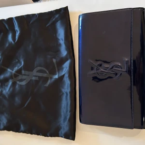 YSL Yves Saint Laurent clutch pochette väska  - Hej!  Finaste midnattsblå  Vintage äkta men utan certifikat  Kommer med original dustbag.  Köpt på märkes second hand men har själv aldrig använt den. 
