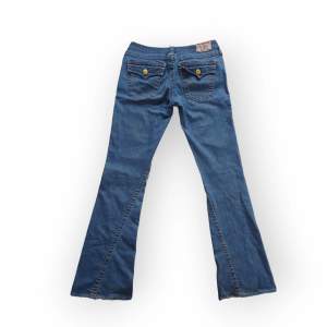 Lågmidjade medium wash flare jeans från True Religion. Mycket bra skick, inga defekter förutom att de är lite slitna längst ned. St: US 29, motsvar EU 36-38. Fråga gärna om fler bilder 💞 Midja:41cm, Höfter: 45cm, innerben: 84cm, benöppning: 25 cm
