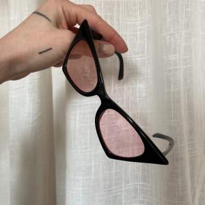Coola solglasögonnmed en kattig form. Svart båge med rosa glas. Använda!