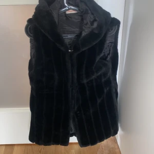 Päls väst - Jätte fin pälsväst med luva i fint skick, det står att de är storlek XL men skulle säga S/M