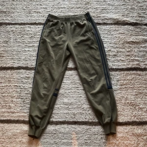 Adidasbyxor - Militärgröna byxor från Adidas, lite vintage, Y2k-vibes! Skulle gissa att de är från 2000-2010-talet. Lite noppiga på muddarna, men det går säkert att fixa.