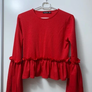 Topp med volang - Säljer en helt ny långarmad topp med volang. 