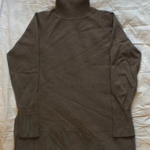 Tröja med polokrage i 100% ull - Säljer min fina tröja i ull då den tyvärr är för liten för mig nu. Den passar XS-S. Den är gjord av 100% merinoull och är grå med bruna undertoner. Den har två små skador, den ena i armhålan och den andra i slitsen på sidan, de kan lagas enkelt💕