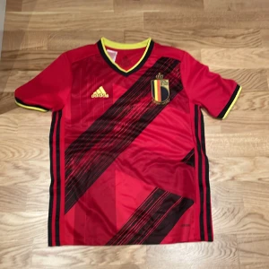 Belgien tröja - Fin somrig fotbollströja med favoritfärgen röd. Aldrig använt och köpt i själva adidas butiken. Storlek 13-14 men passar xs och s
