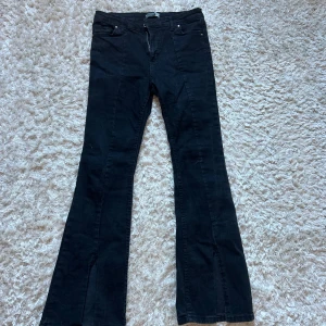 Svarta jeans  - Svarta jeans med slits fram på båda benen, medelhöga i midjan, och skulle säga mellan storlek 36-38🩷🫶🏼