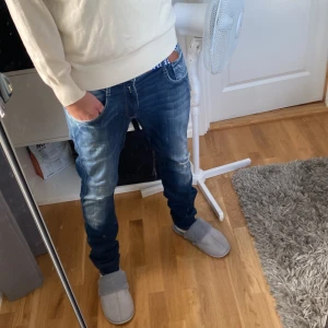 Replay anbass  jeans med slitningar   - Säljer nu mina  sällsynta replay anbass jeans med slitningar och med en riktigt fräsch färg. De är i väldigt fint skick, förutom en superliten defekt  vid Y som syns på bild 4 . säljer för 699. Jag på bilden är 185 cm.