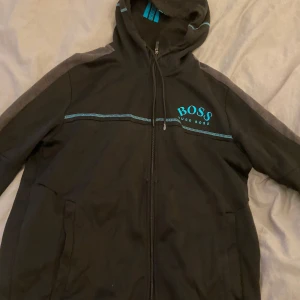 Hugo boss kofta - Tvär fet Hugo boss hoodie från de gamla modellerna, säljs inte längre och är i bra skick, finns en liten slitning vid armbågen, kom pm för fler bilder