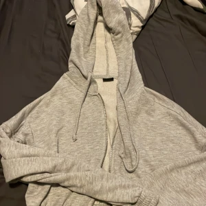 En grå zip hoddie - Storlek xs. Den är använd men fortfarande bra skick super skön. Dock måste ja tyvärr sälja den för den är för lite för mig. Skriv dm om ni har några frågor.