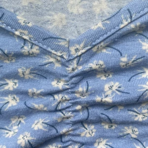 Blå topp från Ginayoung! - Toppen är ljusblå och blommönstrad, har även smockdetalj som man ser på första bilden. Den är lite kort för mig men är i bra skick! 🤩